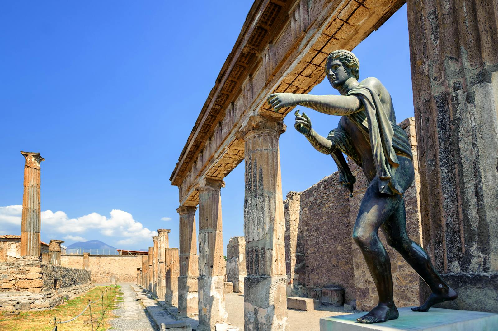 Brązowa statua na pierwszym planie terenu archeologicznego w Pompejach
